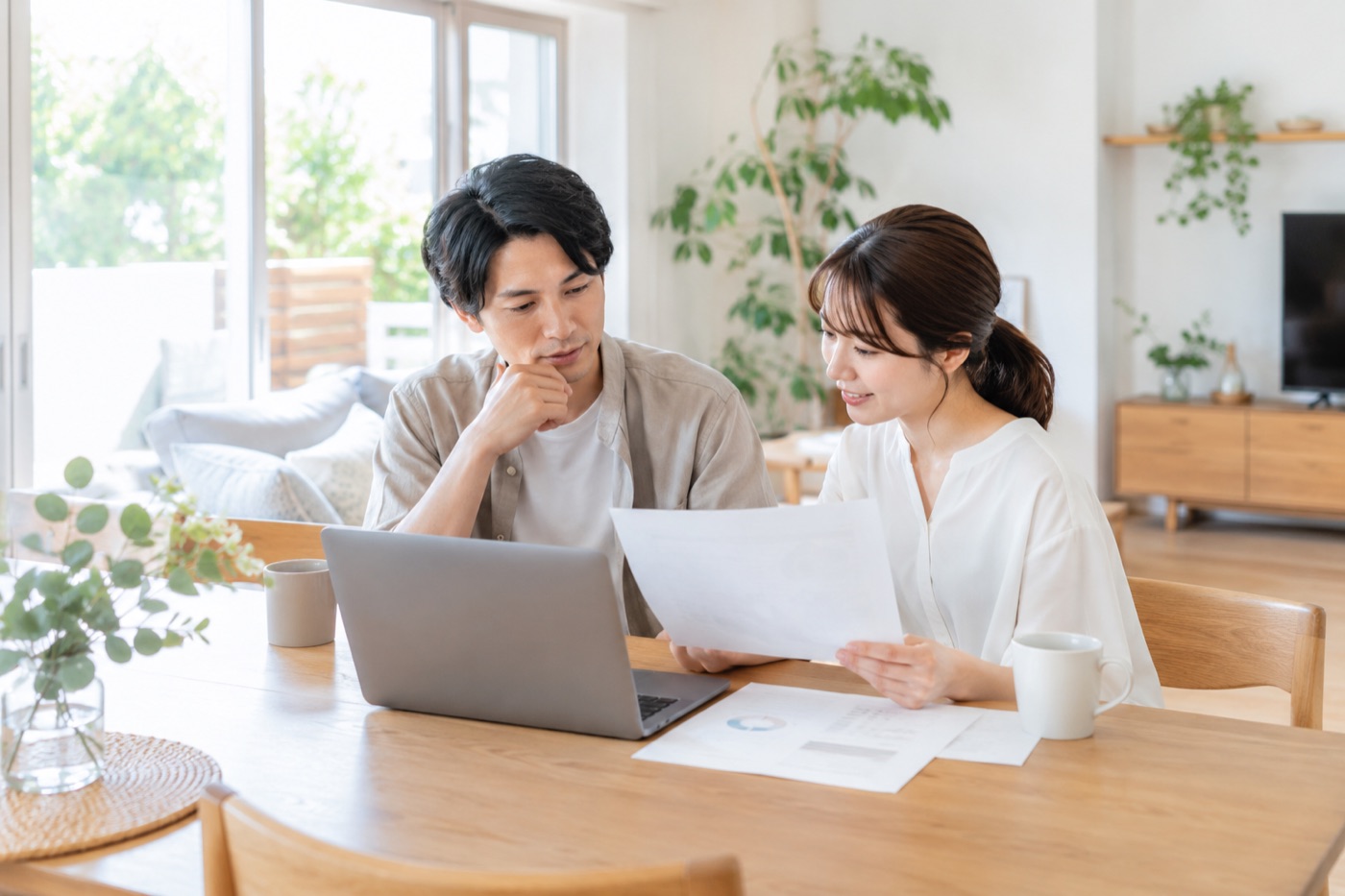 リビングで資料を見ながら相談する夫婦